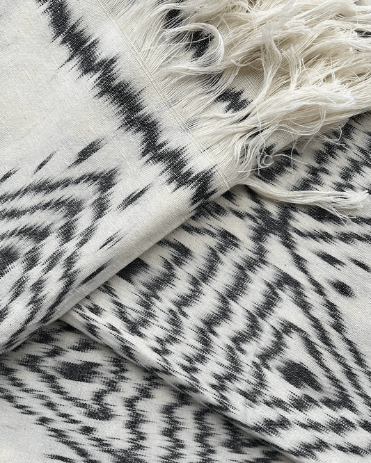 Rękodzielnicza tkanina ikat z czarno-białym geometrycznym wzorem. Unikalna tkanina wykonana tradycyjną techniką ikat idealnie wpisuje się w trendy rękodzieła i sztuki użytkowej.